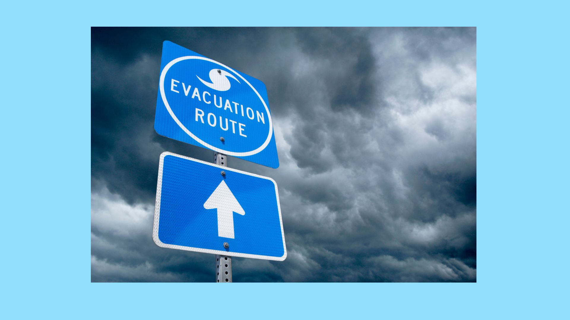 Blue emergency evacuation sign with backdrop of storm clouds